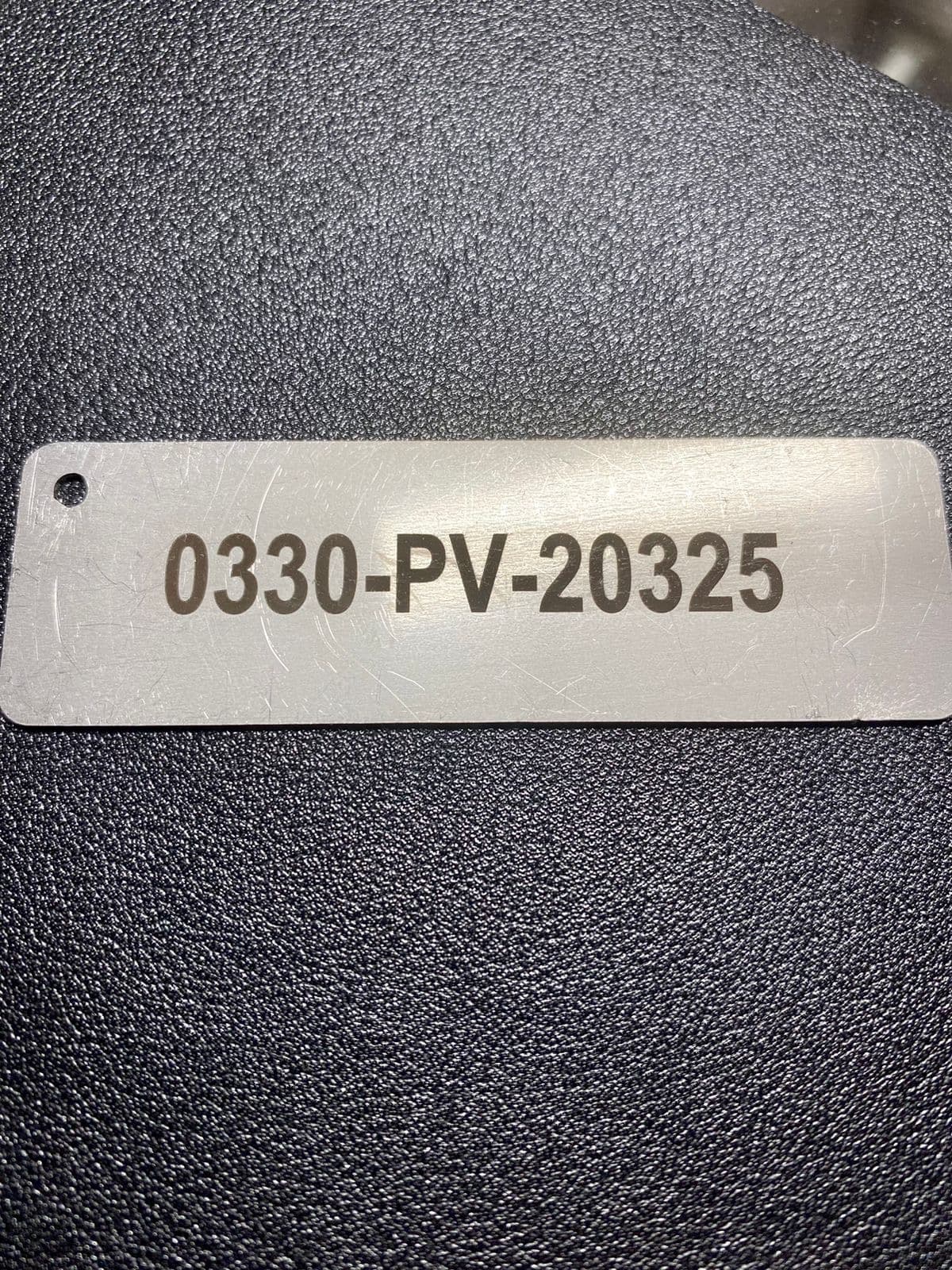 Detalle de placa de acero inoxidable grabada al láser